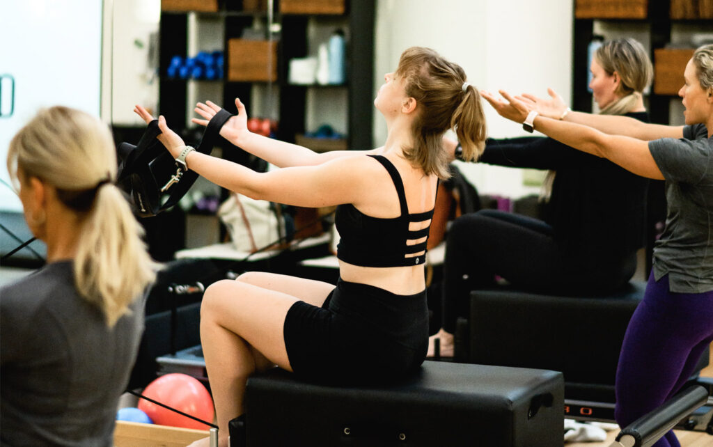 Class doing reformer pilates for a blog about pilates vs strength training