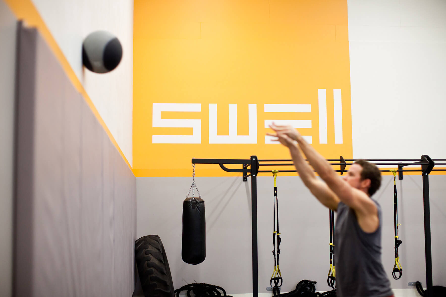 Young man throws medicine ball against wall in Epicenter