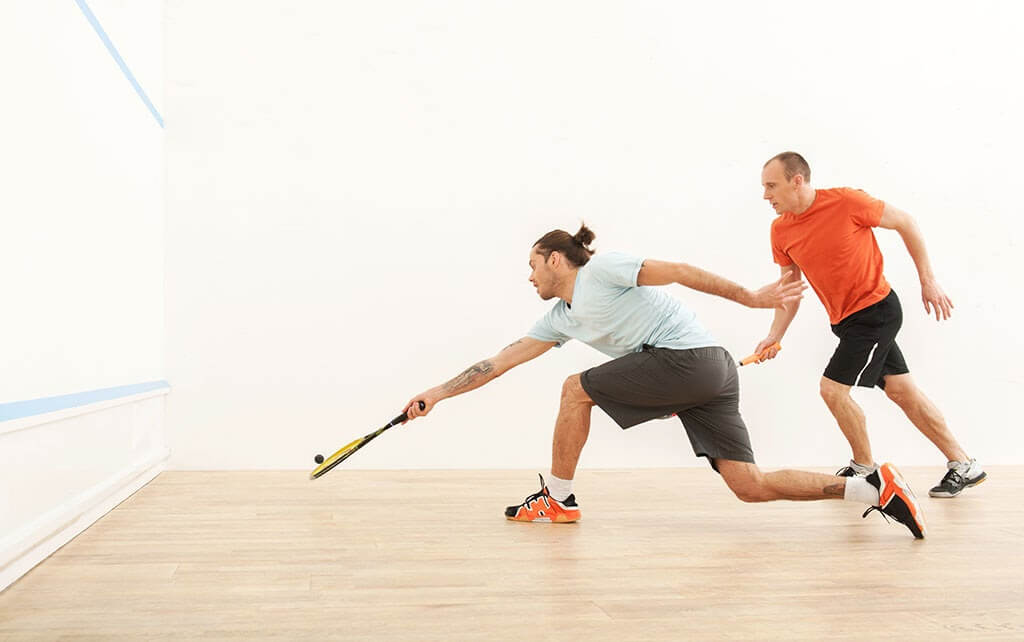 two men play a game on the squash courts
